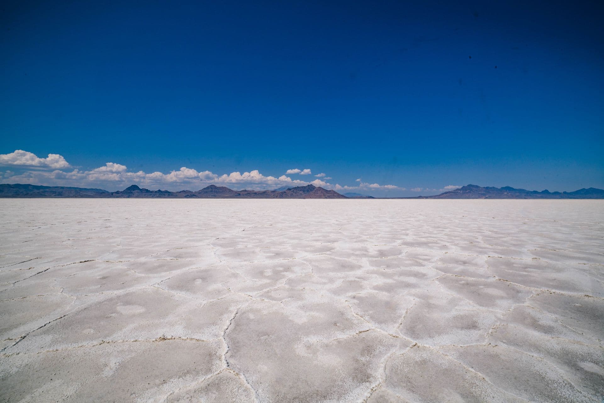 A dry alkali playa stretching to distant desert mountains